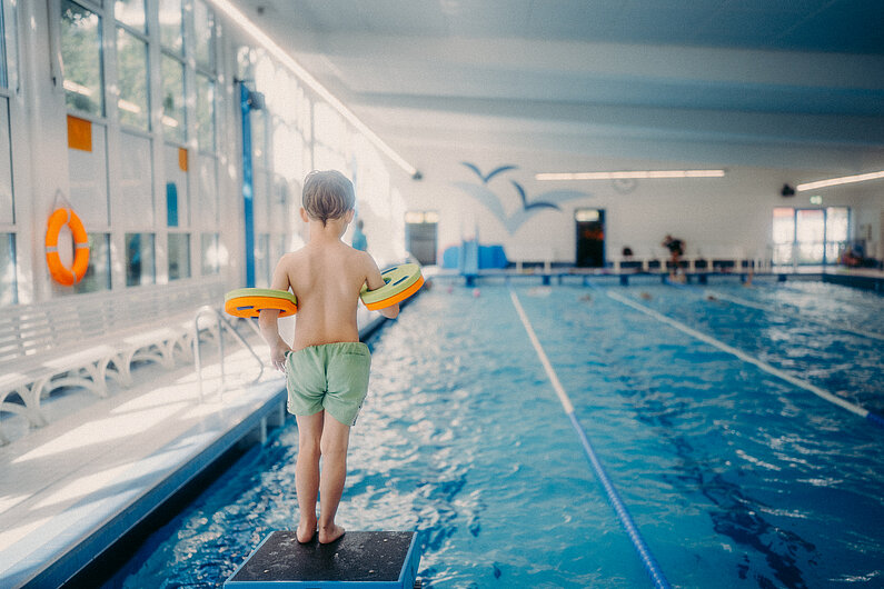 Ein Junge bereitet sich auf einen Sprung ins Wasser vor 