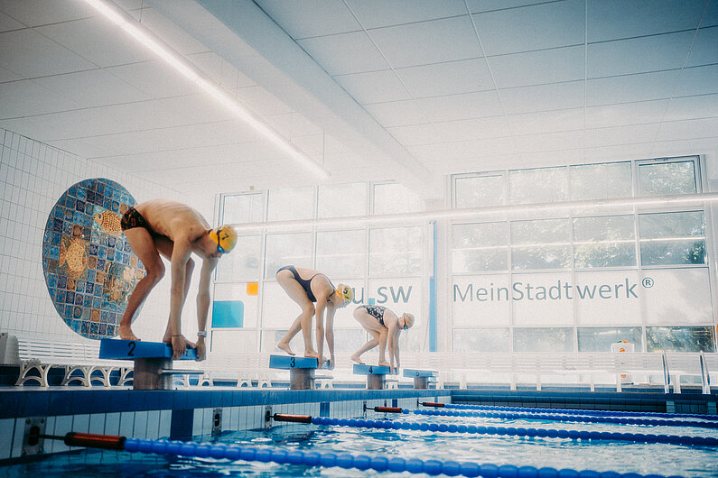 Drei Schwimmer in der Schwimmhalle