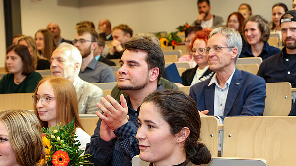 Stipendiaten aus Neubrandenburg mit Blumen in einem Hörsaal.