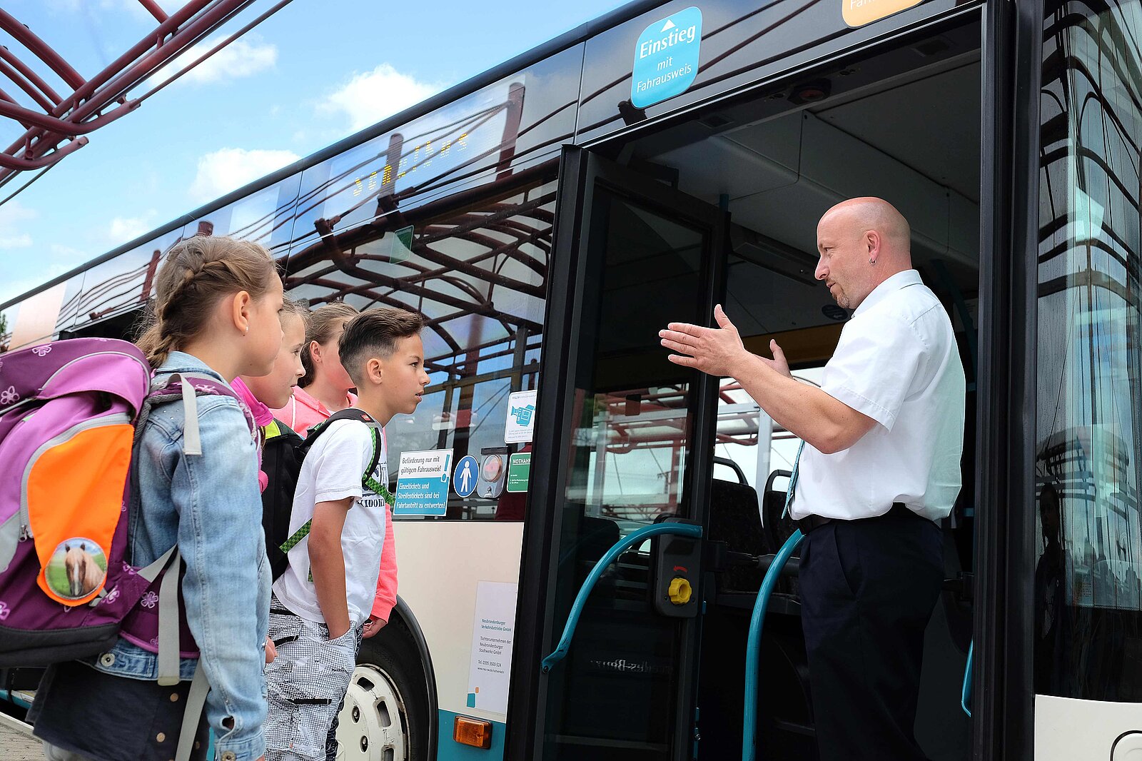 Busfahrer erklärt den Kindern Sicherheitsregeln am Bus