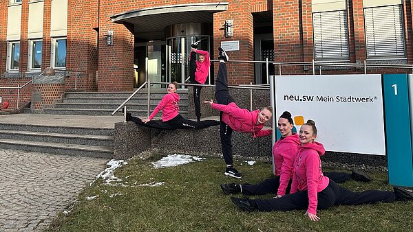 Gymnastinnen posieren in schwarz-pinkem Sportdress vor neu.sw Haupteingang.